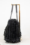 Black textured handbag with chain details on a white background