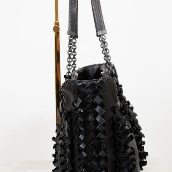 Black woven handbag with chain detail on a white background