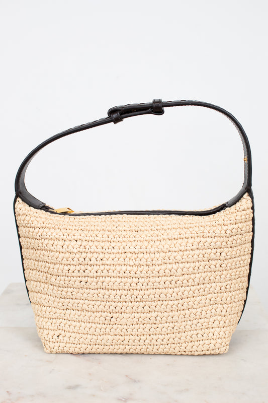 Beige woven handbag with black handle on a light gray background