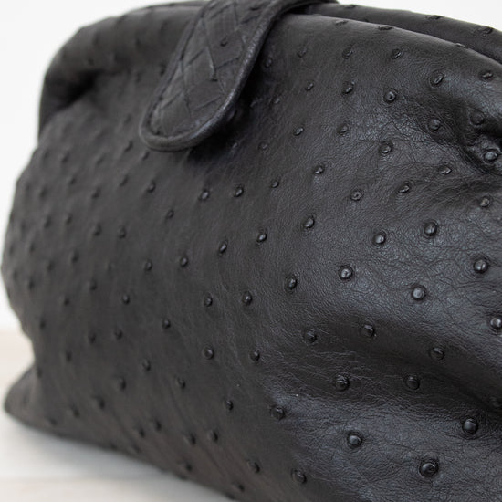Black textured clutch bag on a light background