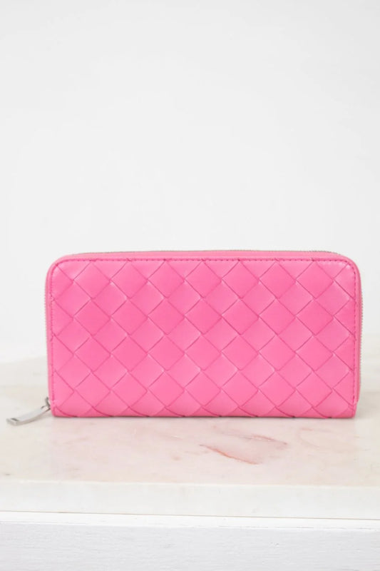 Pink quilted wallet on a white background