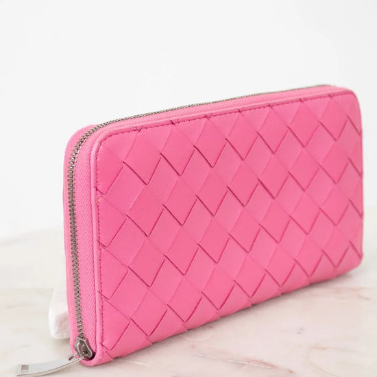 Pink quilted wallet on a light pink surface