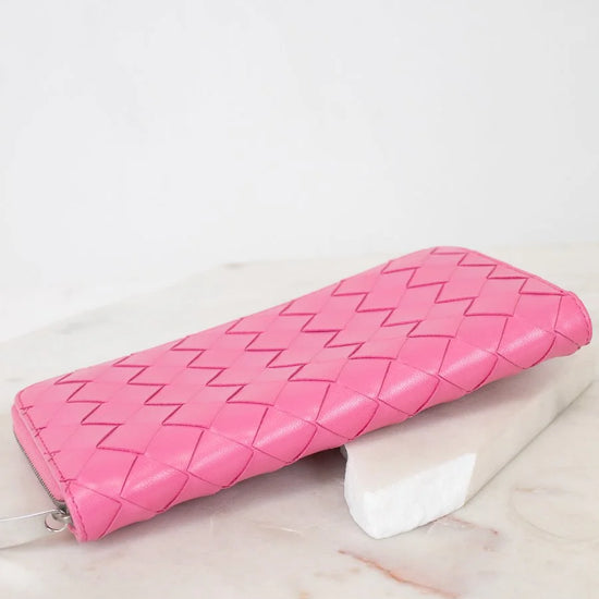 Pink quilted wallet on a light marble surface