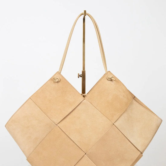 Beige woven handbag on a white background