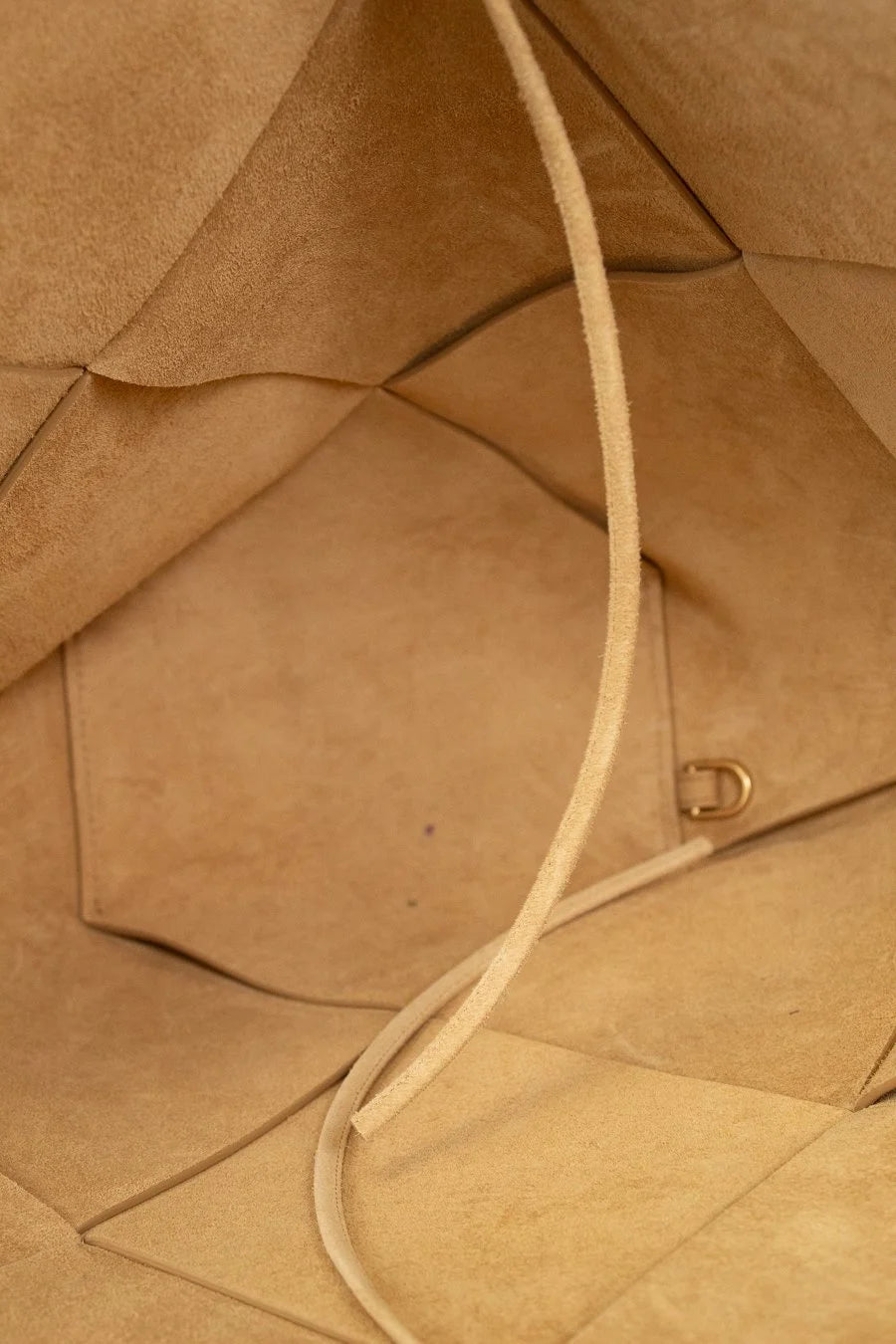 Close-up of a brown leather bag with a strap