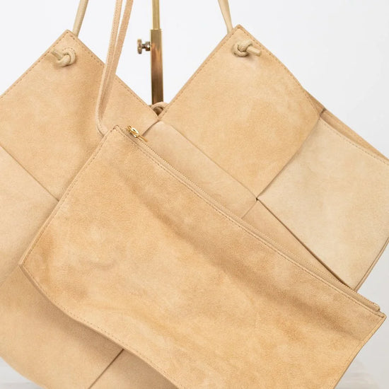 Two beige handbags with leather straps on a white background