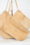 Two beige handbags with leather straps on a white background