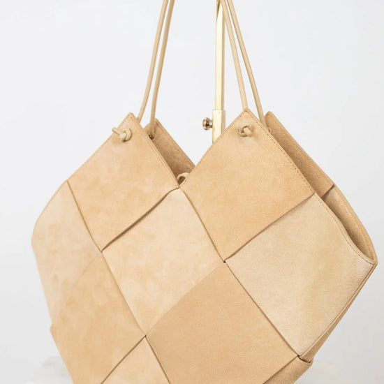 Beige woven handbag on a white background