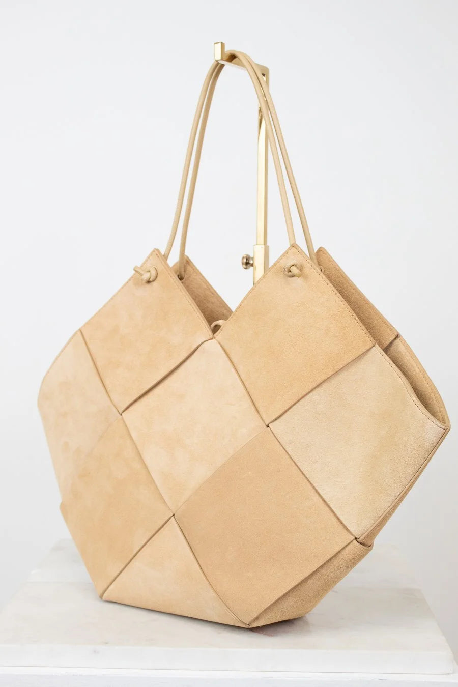 Beige woven handbag on a white background