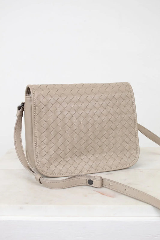 Beige woven handbag on a white background