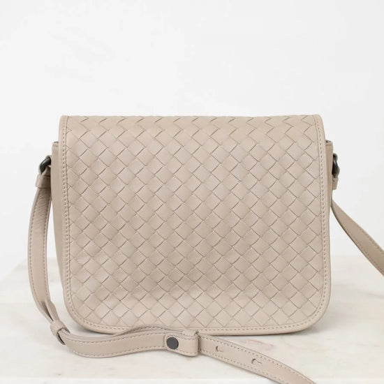 Beige woven handbag on a white background