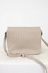 Beige woven handbag on a white background