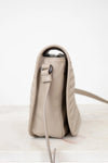 Beige leather bag with a metallic clasp on a white background