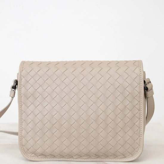 Beige woven handbag on a white background