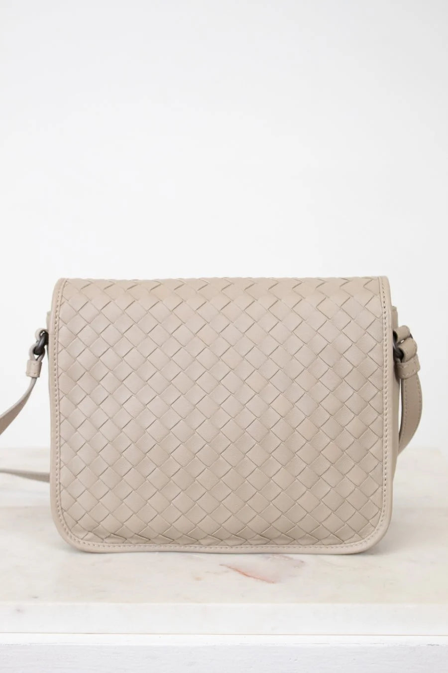 Beige woven handbag on a white background