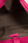 Close-up of a pink and black bag with a visible brand logo.