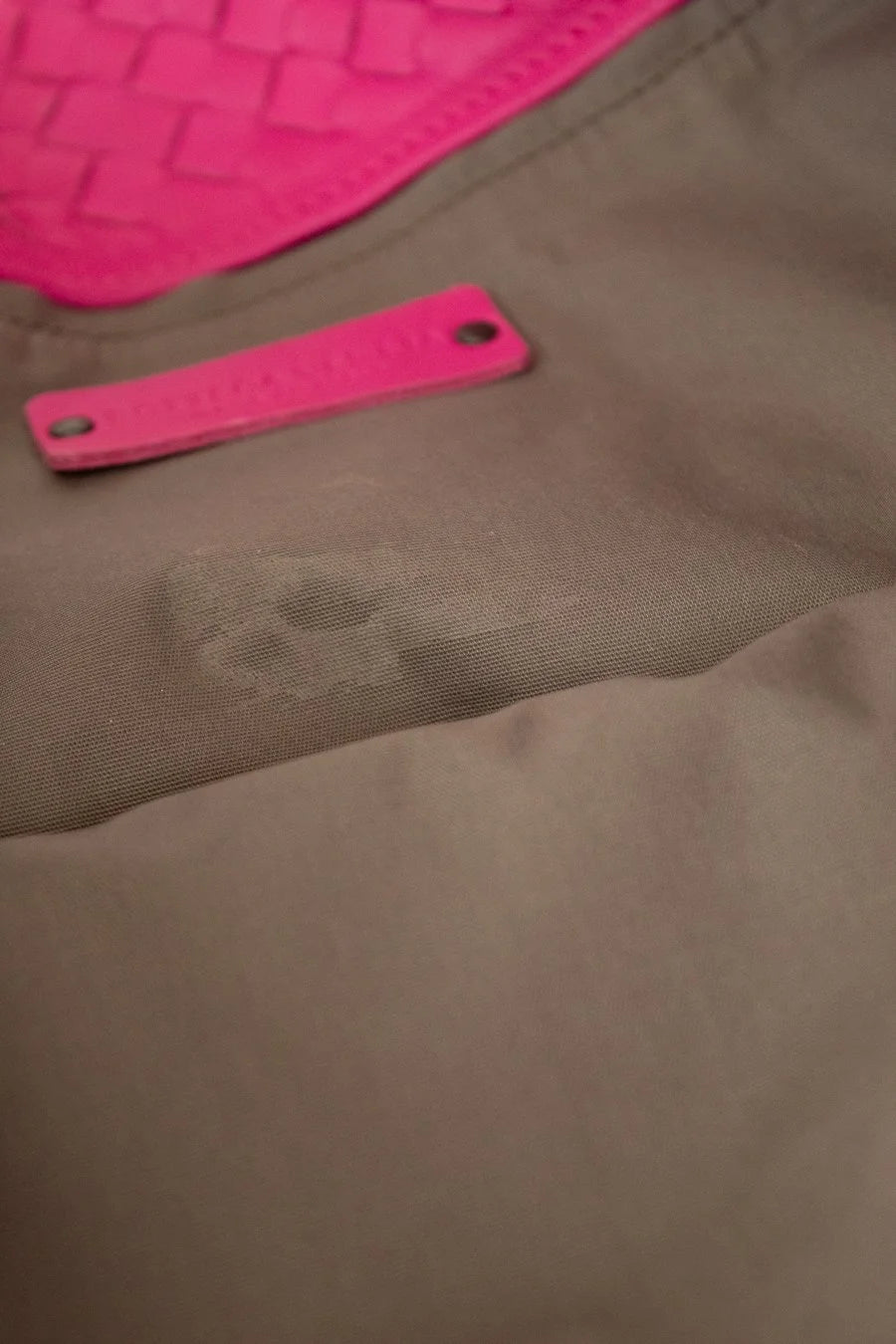 Brown fabric lining with a pink label and pink logo in the corner