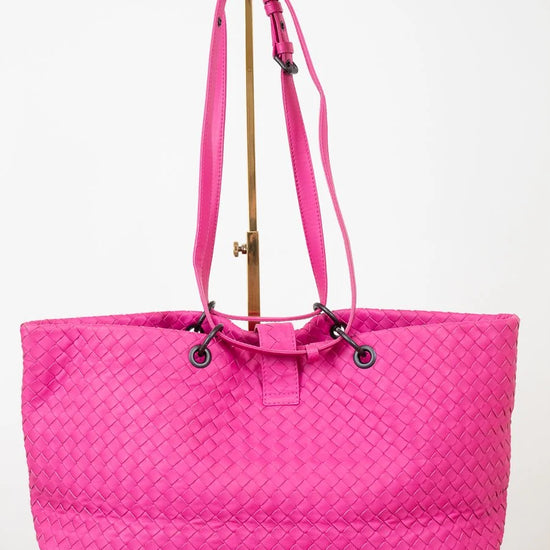 Pink woven tote bag on a white background