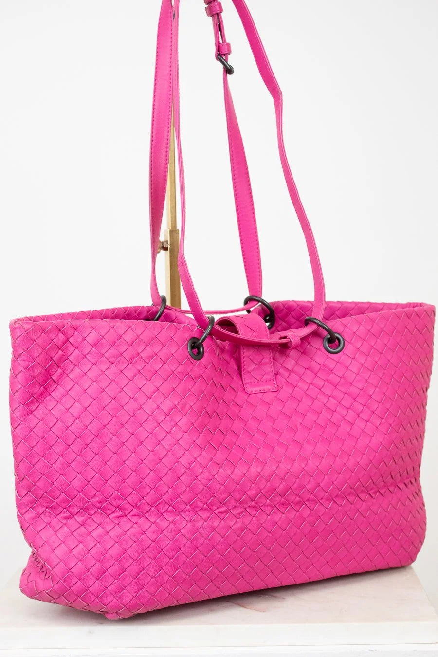 Pink quilted tote bag with a strap on a white background