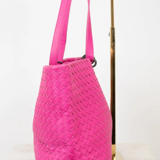 Pink woven handbag on a white background