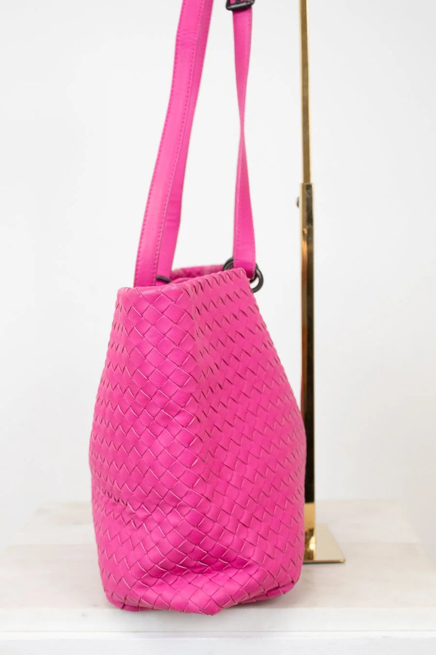 Pink woven handbag on a white background