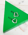 Silver hoop earrings on a Bottega Veneta green triangle box.