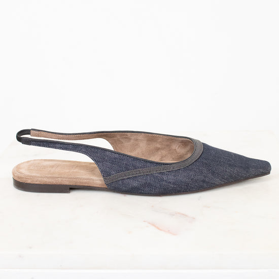 A single pointed-toe slingback flat shoe in a dark blue denim-like fabric, shown from the side against a white background.