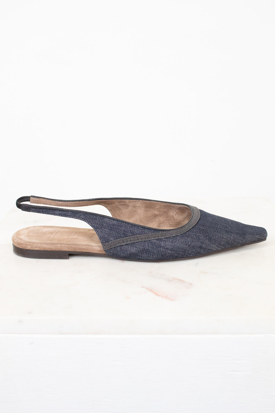 A single pointed-toe slingback flat shoe in a dark blue denim-like fabric, shown from the side against a white background.