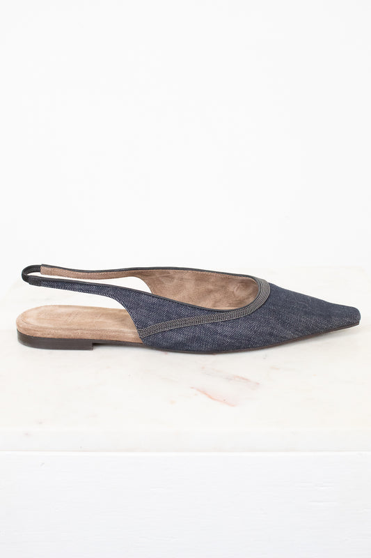 A single pointed-toe slingback flat shoe in a dark blue denim-like fabric, shown from the side against a white background.
