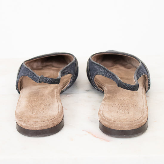 A pair of women's open-toe mule sandals with dark blue-gray textured straps and tan suede-like footbeds, shown from the back on a white surface.