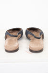 A pair of women's open-toe mule sandals with dark blue-gray textured straps and tan suede-like footbeds, shown from the back on a white surface.