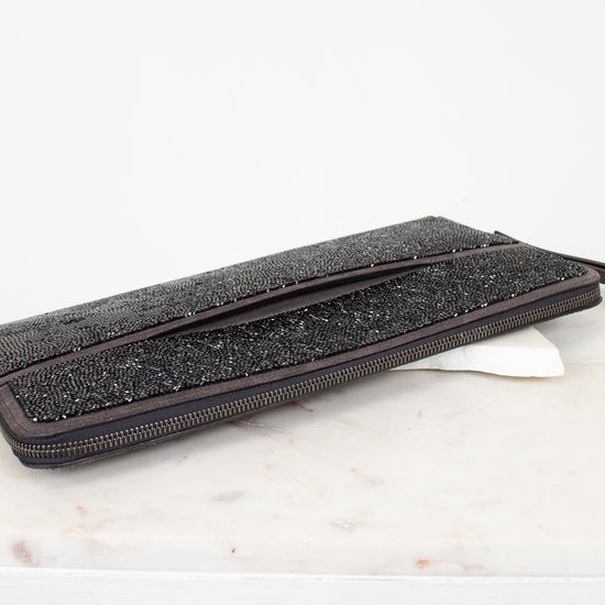 Black glittery clutch bag on a marble surface