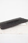 Black glittery clutch bag on a marble surface