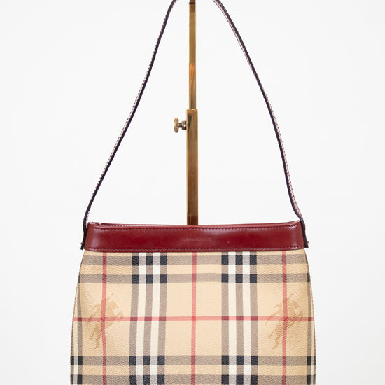 Designer handbag with check pattern and red accents on a white background