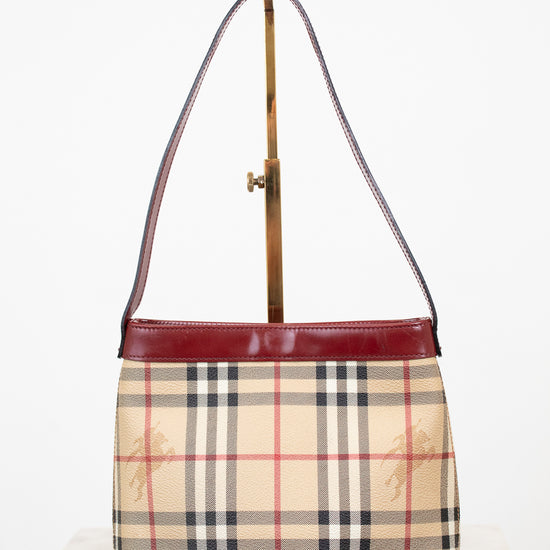 Designer handbag with check pattern and red accents on a white background