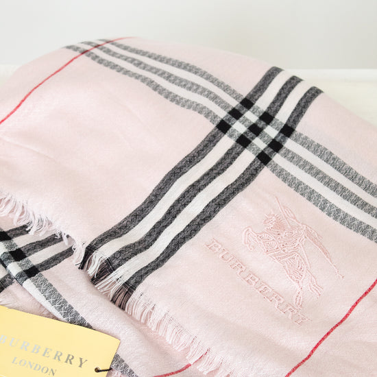 Pink plaid scarf with black and red stripes on a white background, featuring the Burberry logo.