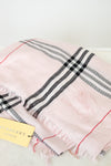 Pink plaid scarf with black and red stripes on a white background, featuring the Burberry logo.