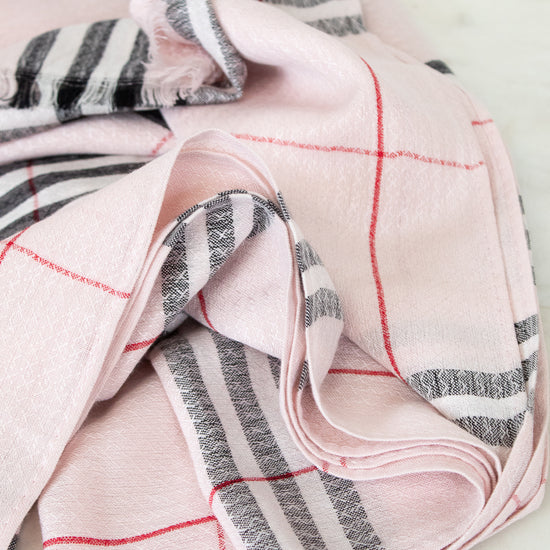 Folded pink and gray checkered fabric on a light background