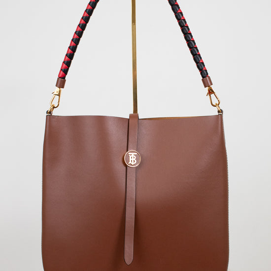 Brown handbag with a braided handle on a white background