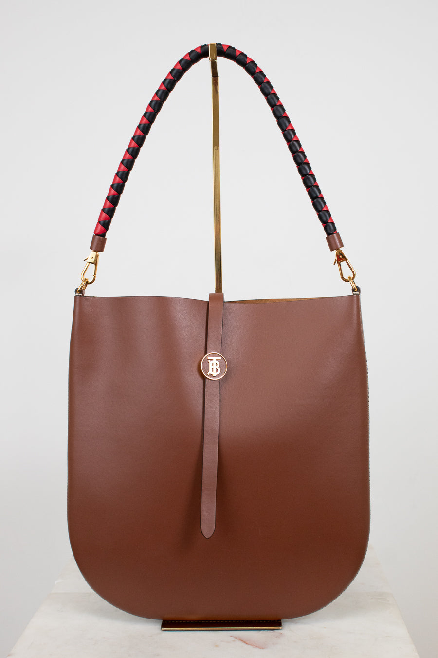 Brown handbag with a braided handle on a white background