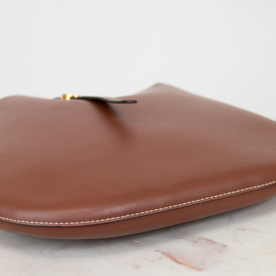 Brown leather base of purse on a light marble surface