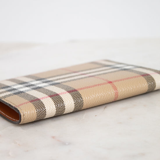 Plaid patterned passport holder on a marble surface