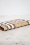 Plaid patterned passport holder on a marble surface