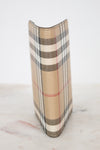 Plaid patterned passport holder on a marble surface
