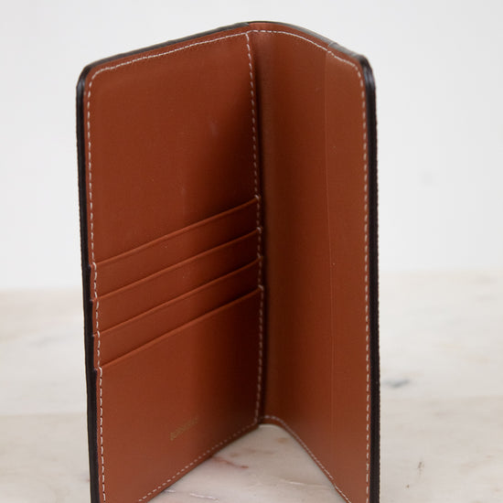 Brown leather wallet open on a light marble surface