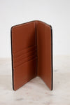 Brown leather wallet open on a light marble surface