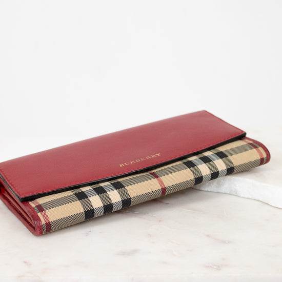 Red wallet with checkered pattern on a white surface