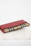 Red wallet with checkered pattern on a white surface