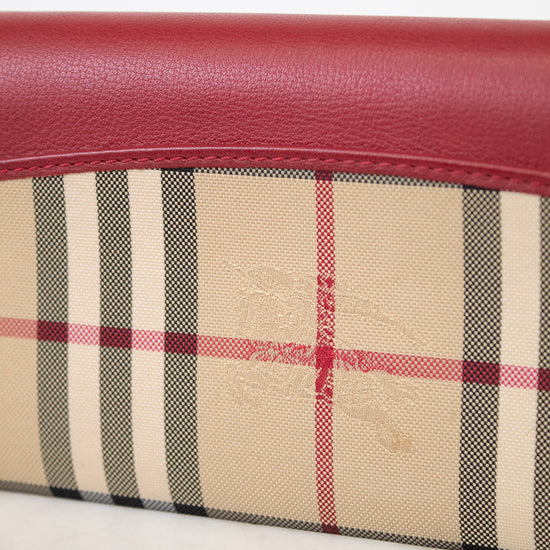 Close-up of a wallet with plaid pattern and red leather trim on a white background