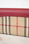 Close-up of a wallet with plaid pattern and red leather trim on a white background